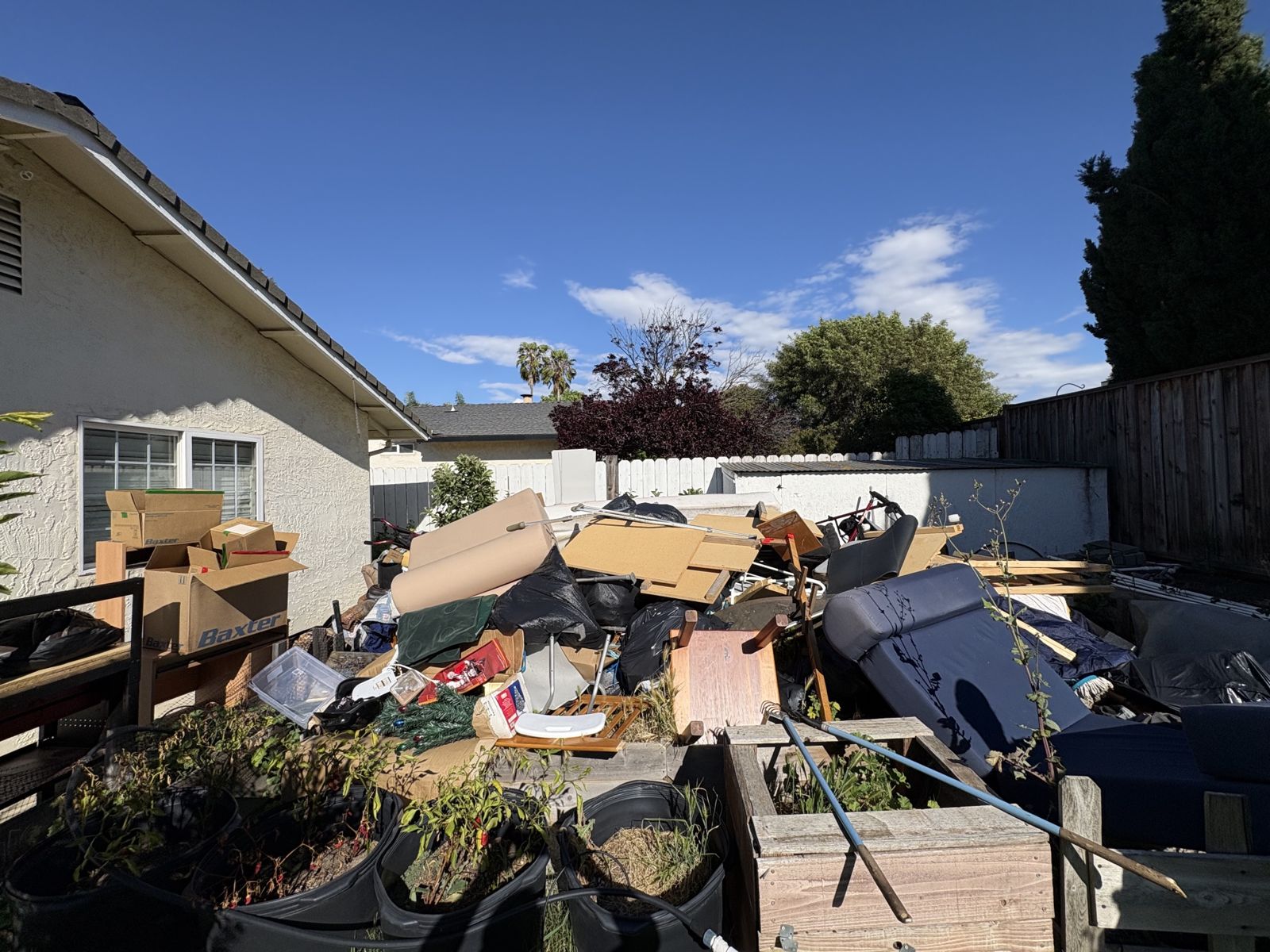 Backyard piled with years of accumulated items before a hoarder cleanout