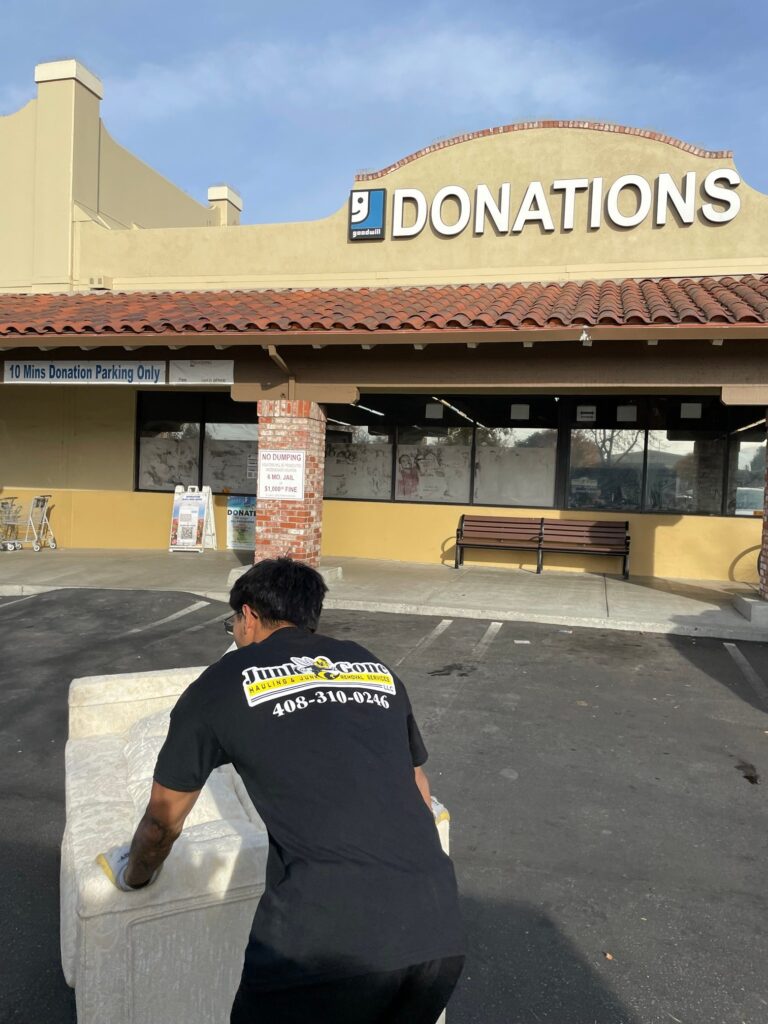 Junk Gone crew member dropping off a couch at a Goodwill donation center