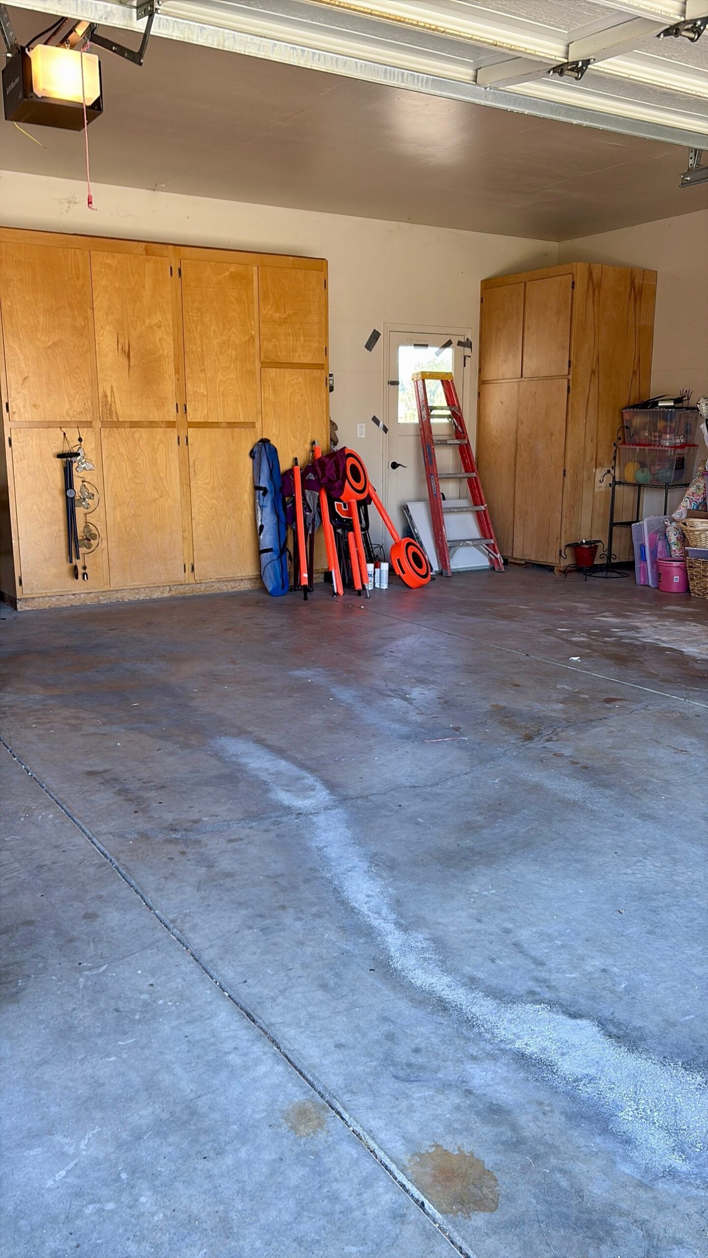 Garage cleanout after: floor cleared and swept, cabinets and ladder left in place
