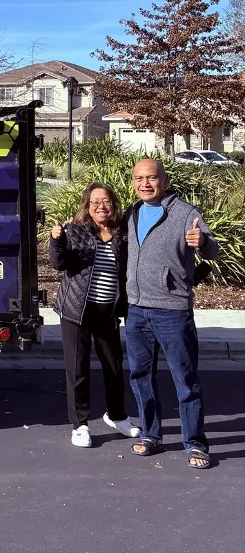 Couple giving a thumbs up next to the Junk Gone trailer