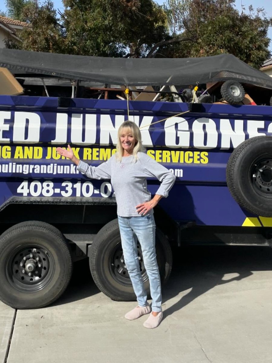 Customer posing with the Junk Gone trailer after the job