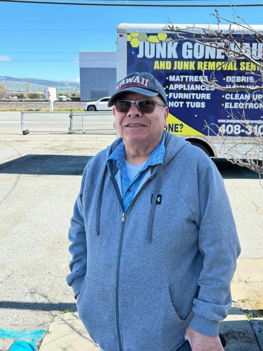Smiling customer in front of the Junk Gone box truck