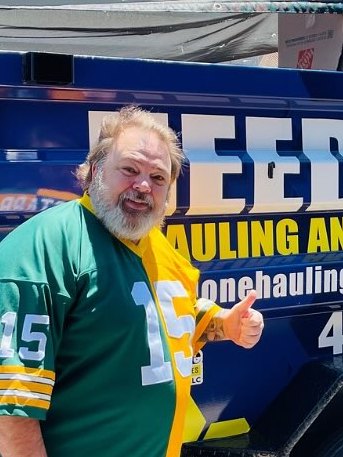 Customer in a football jersey giving a thumbs up by the trailer