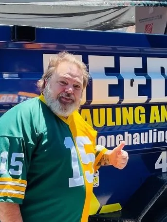 Customer in a football jersey giving a thumbs up by the trailer