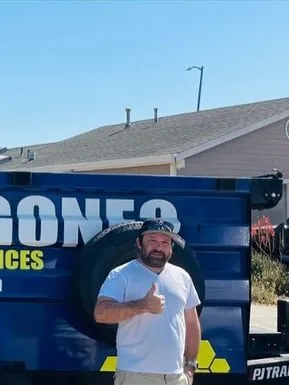 Customer giving a thumbs up by the Junk Gone trailer