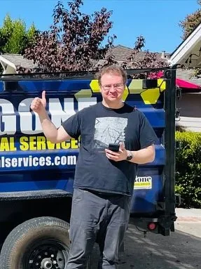 Customer giving a thumbs up next to the Junk Gone trailer