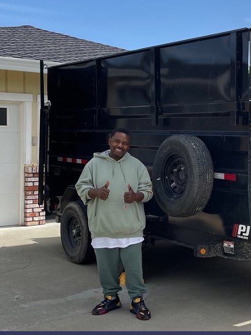 Dumpster rental customer next to the Junk Gone dump trailer
