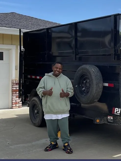 Dumpster rental customer next to the Junk Gone dump trailer