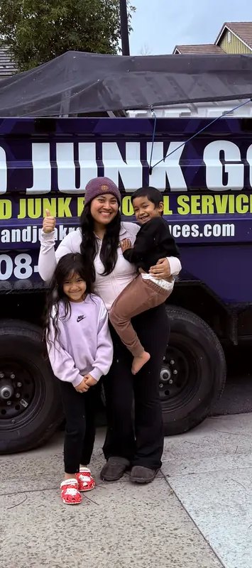 Mom and kids giving a thumbs up in front of the Junk Gone trailer