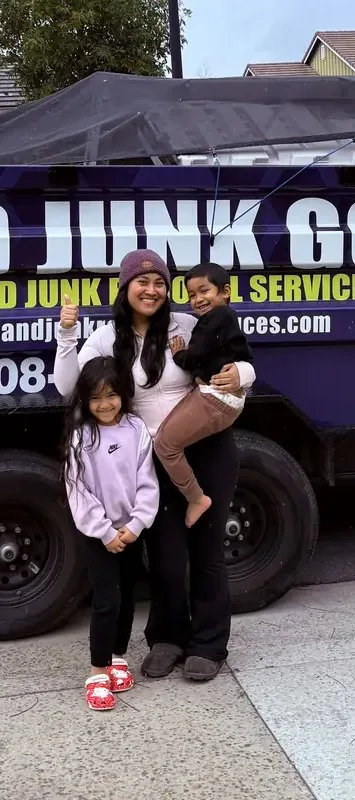Mom and kids giving a thumbs up in front of the Junk Gone trailer