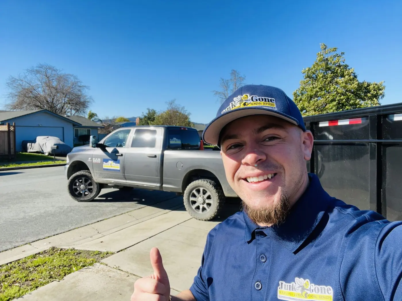 Isaac, owner of Junk Gone, giving a thumbs up next to the truck and trailer