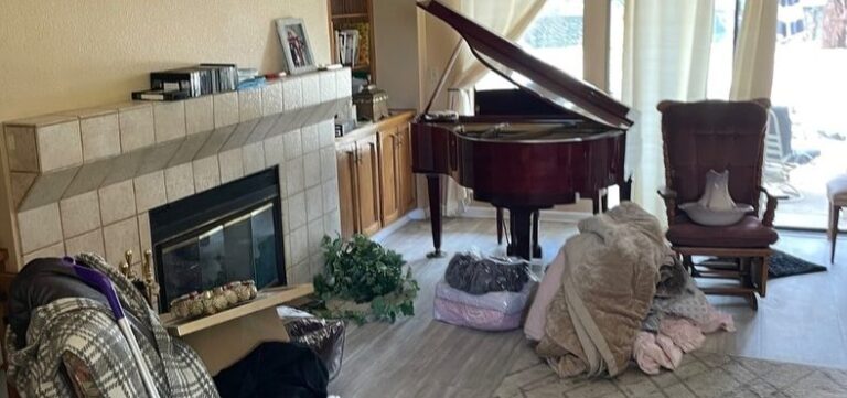 Grand piano in a living room during a whole-home cleanout