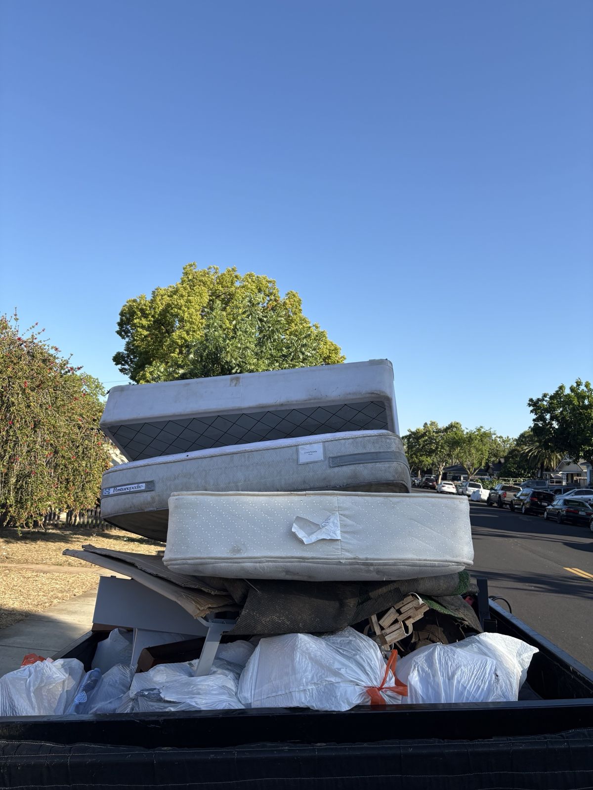 Mattresses and bagged household items loaded for haul-away